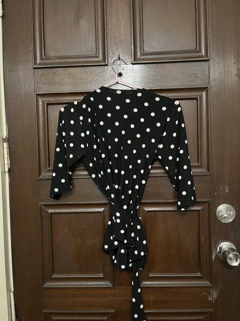 Manila Black and White Polka Dot Wrap Blouse (Category: Blouses) located in Makati City. Submitted by yoursecondbest (Listing ID 1467256322, Image 3). Description: - Color: Black with white polka dots - Brand: Manila - Style: Wrap top with adjustable waist tie - Neckline: V-neck - Sleeves: Half sleeves - Material: Lightweight and comfortable - Versatile casual wear, easy to match with jeans or skirts.