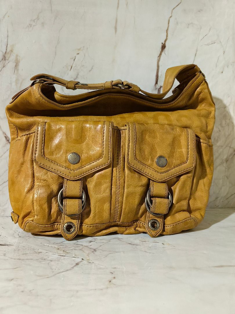 Marc by Marc Jacobs mustard leather shoulder bag (Category: Shoulder Bags) located in Tarlac. Submitted by jeremiah.curator.2026 (Listing ID 1467174458, Image 1). Description: - Brand: Marc by Marc Jacobs - Color/Material: Mustard yellow textured leather - Closure: Secure zip top closure - Pockets: Front flap pockets with magnetic snaps and metal rings, plus an internal zip pocket - Interior: Vibrant blue patterned fabric lining - Details: Side m