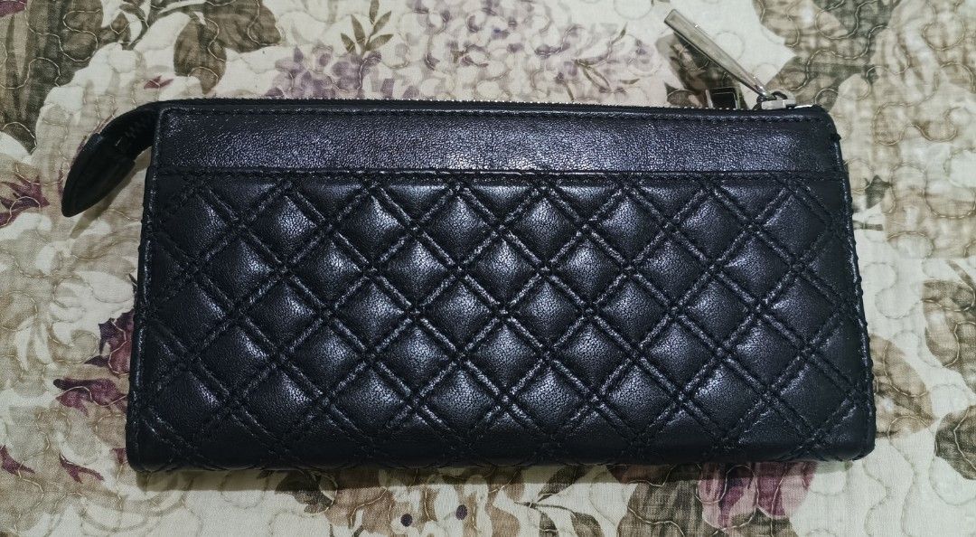 Marc Jacobs Black Quilted Leather Zip Wallet (Category: Wallets & Card holders) located in Capas. Submitted by rayapretty55453 (Listing ID 1467358533, Image 2). Description: Black quilted leather wallet from Marc Jacobs. Zip-around closure with silver-tone hardware. Front features two small flap pockets with push-lock closures and an exterior zipper compartment. Interior has card slots, slip pockets, and fabric lining. Stamped Marc Jacobs Made in