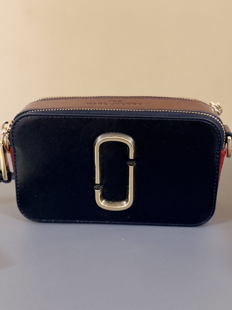 Marc Jacobs Snapshot Camera Bag (Category: Luxury Bags & Wallets) located in Pasig City. Submitted by stuffrightnow (Listing ID 1467238313, Image 2). Description: - Authentic Marc Jacobs Snapshot camera bag - Stunning black, burgundy, and red colorblock design with gold-tone hardware - Classic interlocking J logo on the front - Double zipped compartments for easy organization - Clean leather finish with a well-maintained structured shape - Includ