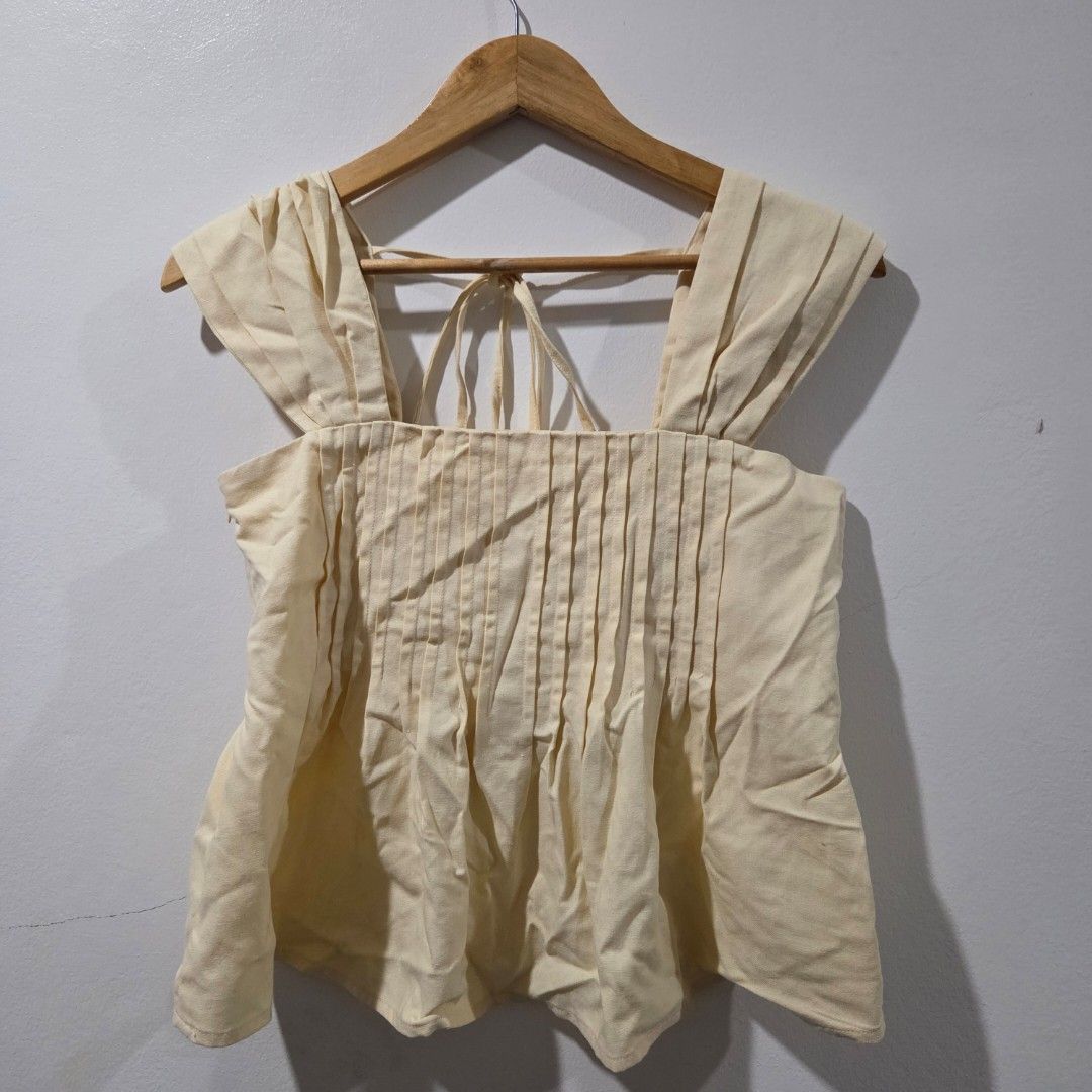 Marvin Le Cream Linen Pleated Top (Category: Sleeveless) located in San Nicolas. Submitted by mllc523 (Listing ID 1467192624, Image 1). Description: Brand: Marvin Le from Vietnam Size: Medium, bust up to 34" Color: Yellow Details: Textured fabric, unique tie-back straps with skinny loops, elegant pleats, with side zipper Condition: Very clean, no stains or flaws I have another piece in color blue, same size and condition, price can be negotiated 