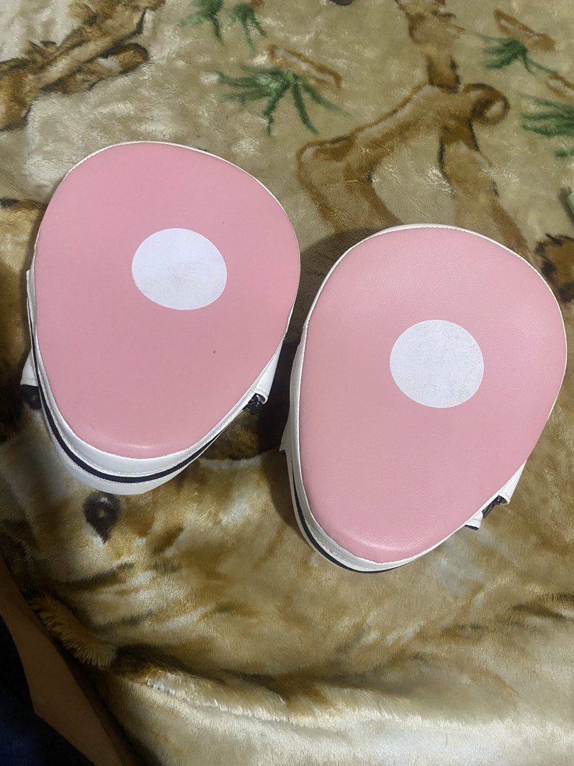 Max Strength Pink and White Focus Mitts Boxing Pads (Category: Combat Sports) located in Manila. Submitted by zealdragon_7d254a (Listing ID 1467251997, Image 2). Description: - Brand: Max Strength - Color: Pink and white - Condition: Minimal wear on striking surfaces, great padding - Design: Circular strike target on the front - Comfort: Hook and loop hand compartment with breathable mesh - Ideal for: Boxing, MMA, and striking training sessions.