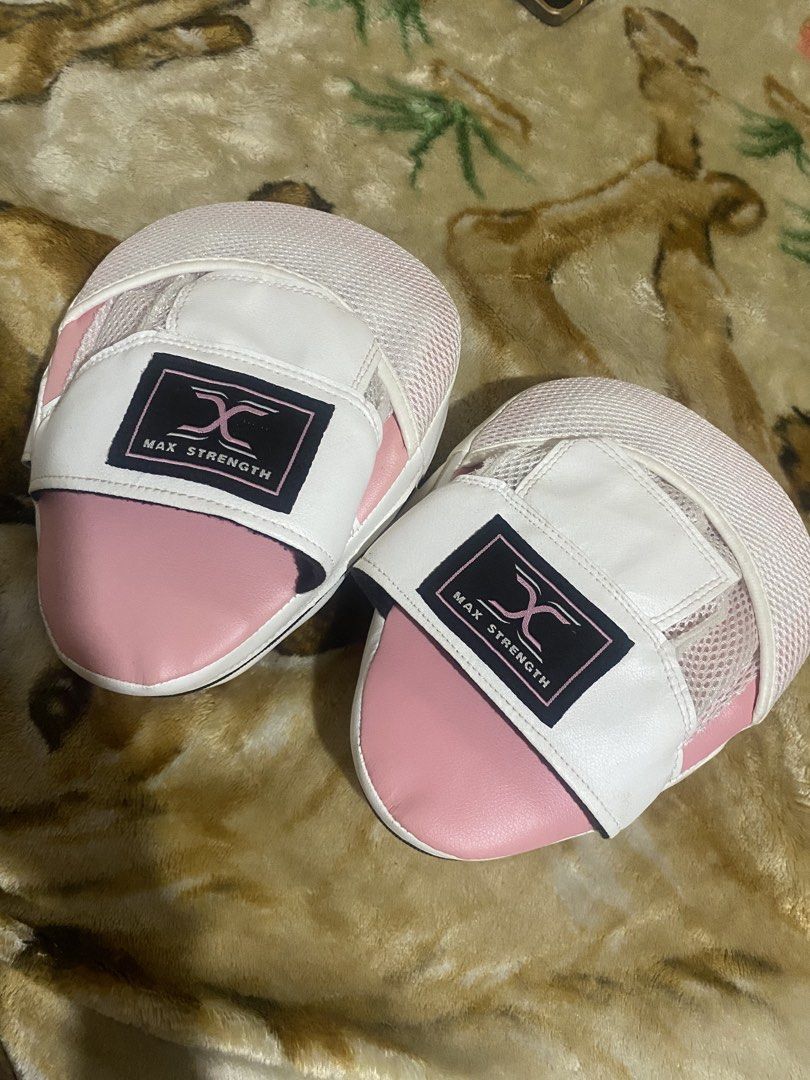 Max Strength Pink and White Focus Mitts Boxing Pads (Category: Combat Sports) located in Manila. Submitted by zealdragon_7d254a (Listing ID 1467251997, Image 1). Description: - Brand: Max Strength - Color: Pink and white - Condition: Minimal wear on striking surfaces, great padding - Design: Circular strike target on the front - Comfort: Hook and loop hand compartment with breathable mesh - Ideal for: Boxing, MMA, and striking training sessions.