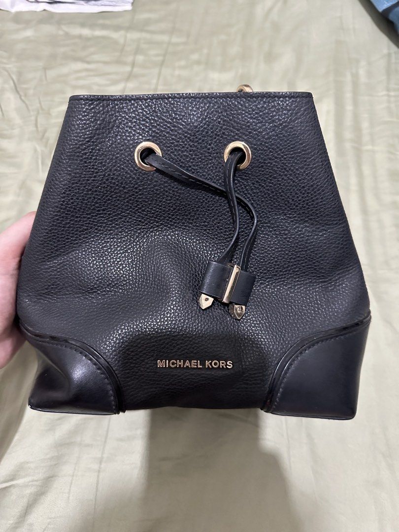 Michael Kors Black Leather Bucket Bag (Category: Luxury Bags & Wallets) located in Santa Rosa. Submitted by babicdln (Listing ID 1467312671, Image 2). Description: - Brand: Michael Kors - Material: Black pebbled leather with smooth leather bottom corner reinforcements - Hardware: Gold-tone lettering and metallic drawstring tips - Closure: Top drawstring closure - Capacity: Compact daily carry, easily fits phone, wallet, and keys with extra interi