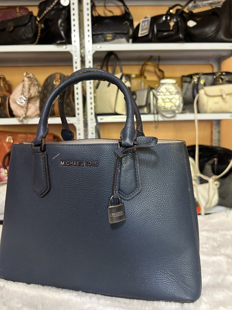 Michael Kors Blue Leather Tote Handbag (Category: Tote Bags) located in Valencia. Submitted by carmzfindsph (Listing ID 1467204243, Image 2). Description: - Brand: Michael Kors - Color: Dark Blue - Material: Premium textured leather - Hardware: Silver-tone - Closure: Magnetic top closure - Handles: Sturdy top handles - Exterior Detail: Signature hanging padlock charm on the front - Interior Details: Spacious with a central zip compartment and cle