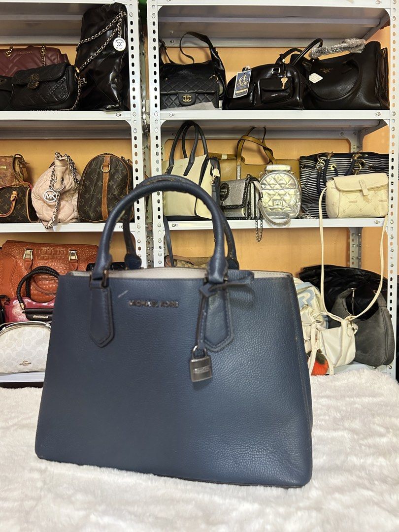 Michael Kors Blue Leather Tote Handbag (Category: Tote Bags) located in Valencia. Submitted by carmzfindsph (Listing ID 1467204243, Image 1). Description: - Brand: Michael Kors - Color: Dark Blue - Material: Premium textured leather - Hardware: Silver-tone - Closure: Magnetic top closure - Handles: Sturdy top handles - Exterior Detail: Signature hanging padlock charm on the front - Interior Details: Spacious with a central zip compartment and cle