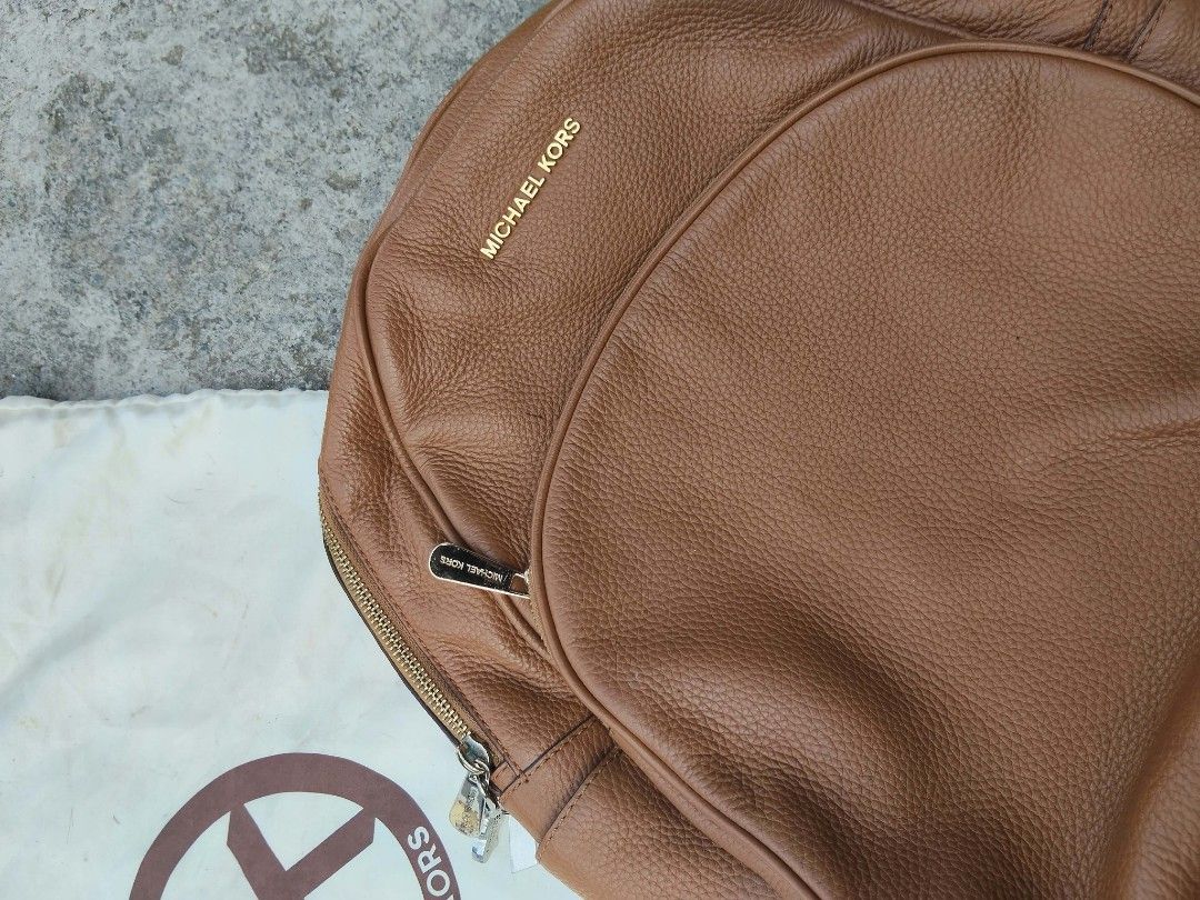 Michael Kors Brown Pebbled Leather Backpack (Category: Backpacks) located in Lucena. Submitted by ziboldawg (Listing ID 1467346455, Image 1). Description: - Brand: Michael Kors - Material: Premium tan pebbled leather - Hardware: Elegant gold-tone hardware - Compartments: Secure top zip closure and handy front zippered pocket - Interior: Signature Michael Kors logo fabric lining with generous space for daily essentials - Inclusion: Original dust b