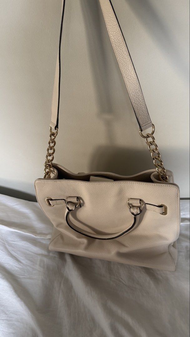 Michael Kors Cream Pebble Leather Tote Shoulder Bag (Category: Luxury Bags & Wallets) located in Cebu City. Submitted by bitten_ (Listing ID 1467213321, Image 3). Description: - Brand: Michael Kors - Material: Cream pebble leather with gold hardware - Design: Signature MK front plaque, double top handles, and chic chain-link shoulder straps - Interior: MK fabric lining with a secure middle zippered compartment, slip pockets, and snap closure stra