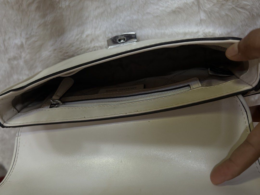 Michael Kors White Shoulder Bag (Category: Shoulder Bags) located in Valencia. Submitted by carmzfindsph (Listing ID 1467206797, Image 3). Description: - Brand: Michael Kors - Color: White with silver-tone hardware - Closure: Front flap with lock clasp - Strap: Single strap accented with a logo charm - Interior: Fabric-lined with a convenient zipped pocket and brand tag - Condition: Pre-loved with visible scuffs and dirt marks on the white leathe