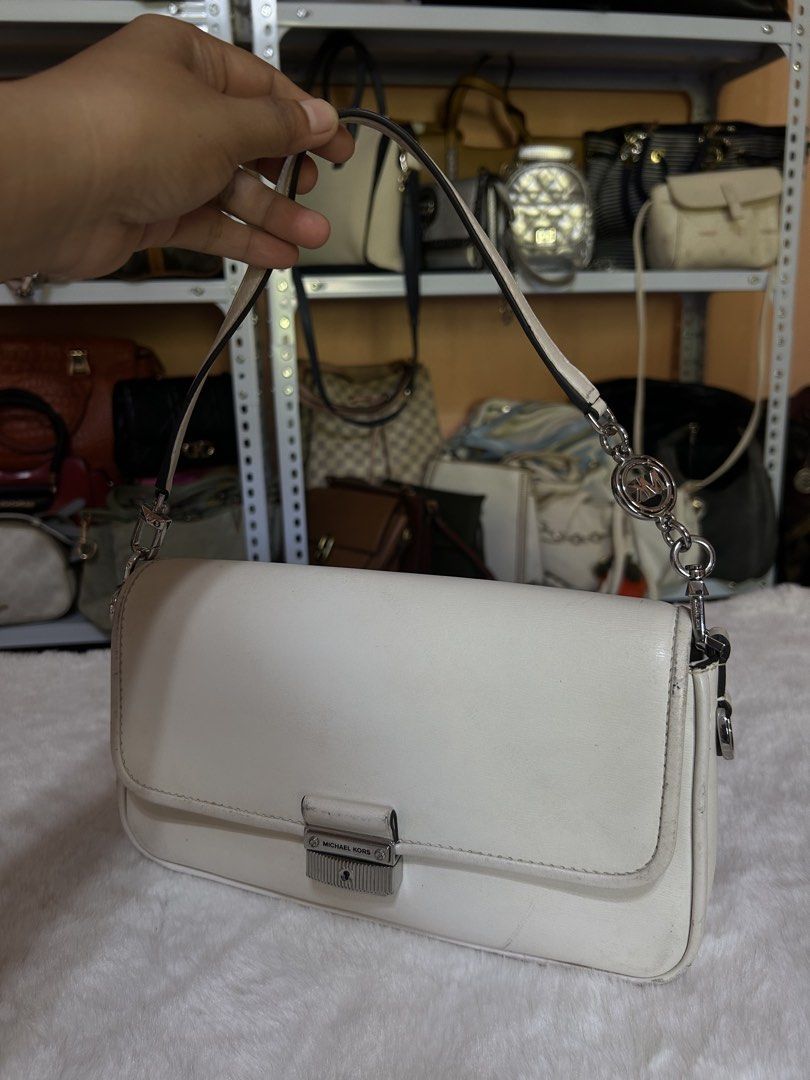 Michael Kors White Shoulder Bag (Category: Shoulder Bags) located in Valencia. Submitted by carmzfindsph (Listing ID 1467206797, Image 2). Description: - Brand: Michael Kors - Color: White with silver-tone hardware - Closure: Front flap with lock clasp - Strap: Single strap accented with a logo charm - Interior: Fabric-lined with a convenient zipped pocket and brand tag - Condition: Pre-loved with visible scuffs and dirt marks on the white leathe