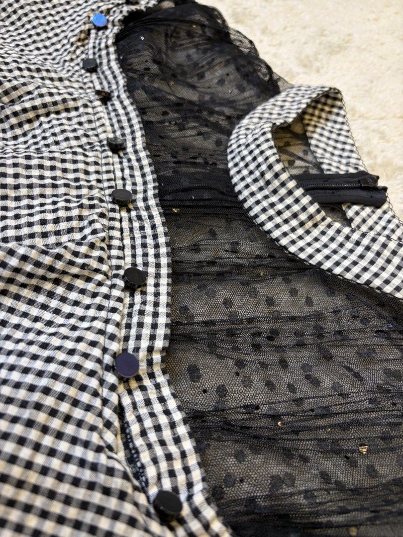 Midnight Gingham Belle (Category: Dresses) located in Batangas. Submitted by nicki0001 (Listing ID 1467249538, Image 2). Description: 🖤 ITEM: Midnight Gingham Belle * Black and white gingham print with a statement ruffle overlay * Sheer mesh neckline with a unique sparkly detail * Thick fabric, back zipper, and pockets on both sides Giving classy Korean doll vibes. Pair it with Mary Janes, a mini handbag, and dainty earrings for that chic, femin