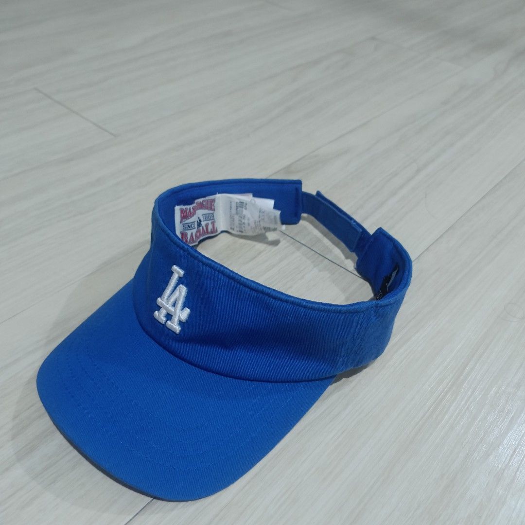 MLB Los Angeles Dodgers Blue Visor Cap (Category: Caps & Hats) located in Manila. Submitted by ghello99 (Listing ID 1467267682, Image 2). Description: - Authentic MLB visor in a bright royal blue color - Features embroidered white LA logo on the front - Adjustable velcro back strap with embroidered MLB batterman logo - Stylish contrast stitching on the brim - Includes interior Major League Baseball text tag, size tag, and care instructions.