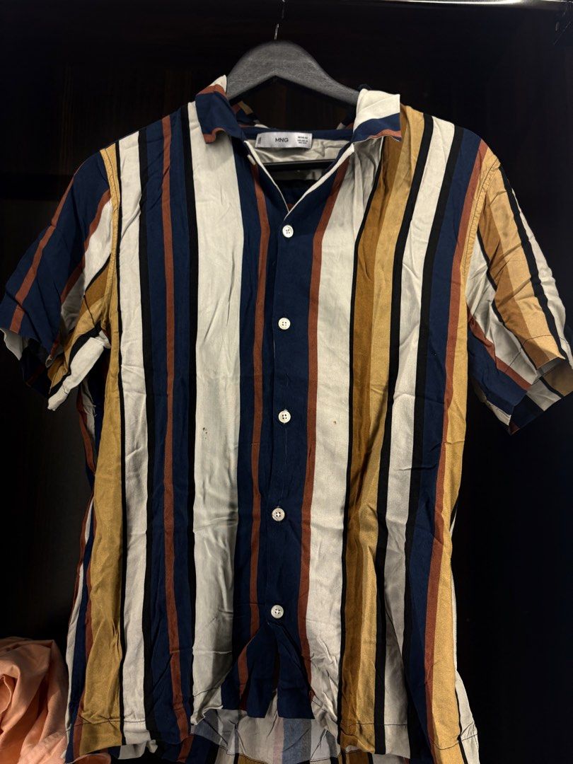 MNG Striped Short Sleeve Button Up Shirt (Category: Shirts) located in Angeles City. Submitted by curt_morales (Listing ID 1467326022, Image 1). Description: - Brand: MNG - Style: Short sleeve button-up with collared neck and white front buttons - Design: Multi-color vertical stripes (navy blue, mustard yellow, brown, white, and black) - Fit: Regular fit, lightweight fabric ideal for warm weather - Condition: Worn a few times, freshly washed, and