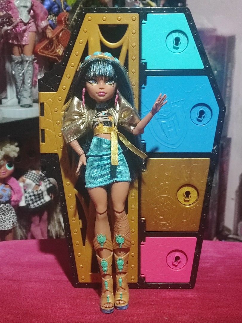 Monster High Skulltimate Secrets Cleo De Nile Doll (Category: Figurines & Statues) located in Manila. Submitted by jadeparkss13666 (Listing ID 1467210839, Image 1). Description: - Character: Cleo De Nile from Monster High Skulltimate Secrets - Condition: Great, stands securely - Complete Outfit: Dark blue hair, gold crop top, shiny blue skirt, gold accessories, and tall wrap sandals - Inclusion: Colorful coffin locker storage case - Perfect for c