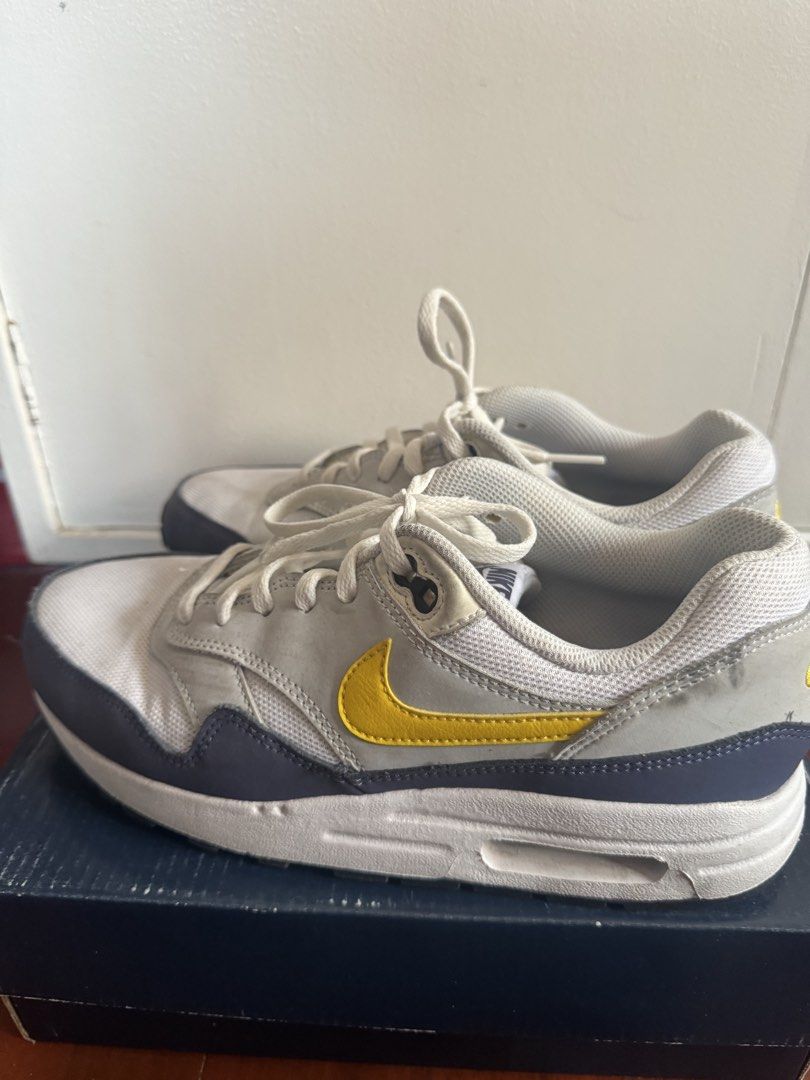Nike Air Max 1 White Yellow Grey (Category: Babies & Kids Fashion) located in Batangas. Submitted by GDW98 (Listing ID 1467178889, Image 2). Description: - Model: Nike Air Max 1 - Colorway: White mesh base, grey suede overlays, striking yellow swooshes, and dark navy blue mudguard - Details: Gold Nike Air embroidery on the heel, classic visible bubble cushioning in the white midsole - Fit & Style: Comfortable for daily wear with a clean aesthetic