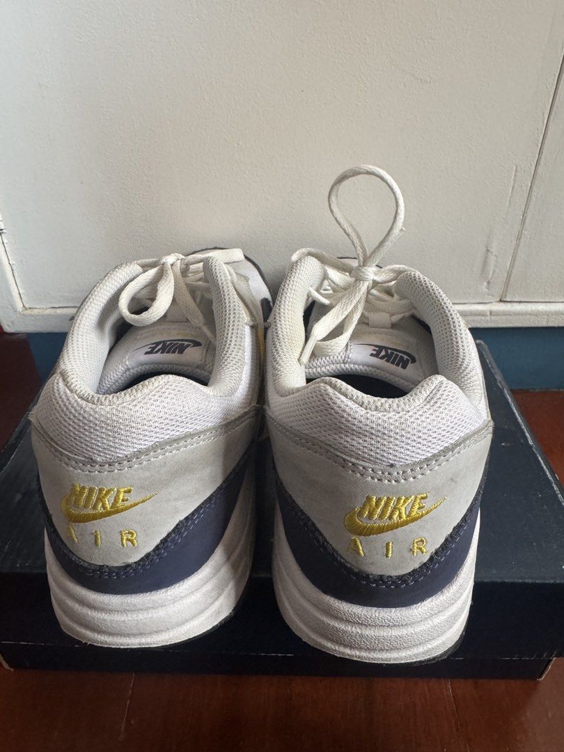 Nike Air Max 1 White Yellow Grey (Category: Babies & Kids Fashion) located in Batangas. Submitted by GDW98 (Listing ID 1467178889, Image 3). Description: - Model: Nike Air Max 1 - Colorway: White mesh base, grey suede overlays, striking yellow swooshes, and dark navy blue mudguard - Details: Gold Nike Air embroidery on the heel, classic visible bubble cushioning in the white midsole - Fit & Style: Comfortable for daily wear with a clean aesthetic