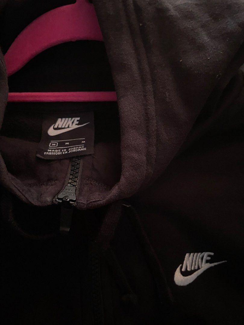 Nike Black Zip-Up Hoodie Size M (Category: Hoodies) located in Davao. Submitted by vin.my (Listing ID 1467204577, Image 2). Description: Black Nike zip-up hoodie with embroidered white logo on the chest. Full zip front, adjustable hood drawstrings, and split kangaroo pockets. Size M tag on the collar, made in Jordan. Interior care label lists style number 804389-010. Cotton blend material, comfortable everyday fit..