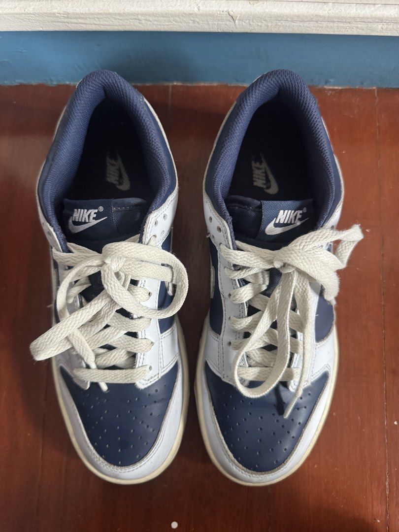 Nike Dunk Low Midnight Navy White Sneakers (Category: Babies & Kids Fashion) located in Batangas. Submitted by GDW98 (Listing ID 1467178695, Image 3). Description: Nike Dunk Low in midnight navy and white colorway. Low-top skate style with classic perforated toe box and chunky laces. White leather panels paired with dark blue overlays. Midsole shows some natural yellowing and scuffs from wear. Tread on the bottom has plenty of grip left. Navy inn
