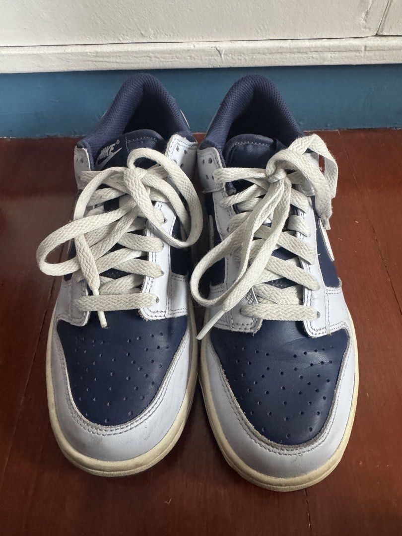 Nike Dunk Low Midnight Navy White Sneakers (Category: Babies & Kids Fashion) located in Batangas. Submitted by GDW98 (Listing ID 1467178695, Image 1). Description: Nike Dunk Low in midnight navy and white colorway. Low-top skate style with classic perforated toe box and chunky laces. White leather panels paired with dark blue overlays. Midsole shows some natural yellowing and scuffs from wear. Tread on the bottom has plenty of grip left. Navy inn