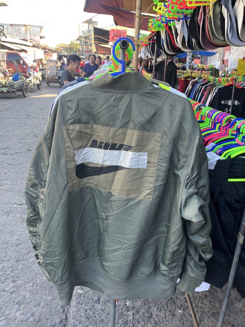 Nike Green Bomber Jacket Size XL (Category: Coats, Jackets and Outerwear) located in Pontevedra. Submitted by thrift01 (Listing ID 1467262783, Image 2). Description: - Brand: Nike - Item: Bomber Jacket - Color: Green with orange interior lining - Size: XL (Standard fit) - Details: Full zip closure, metallic Nike swoosh logo on chest, large back graphic patch, and left sleeve utility pocket - Origin: Made in Vietnam - Condition: Excellent.