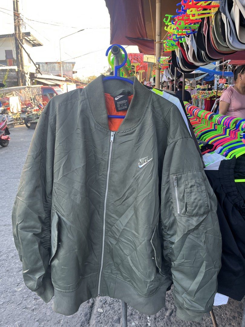 Nike Green Bomber Jacket Size XL (Category: Coats, Jackets and Outerwear) located in Pontevedra. Submitted by thrift01 (Listing ID 1467262783, Image 1). Description: - Brand: Nike - Item: Bomber Jacket - Color: Green with orange interior lining - Size: XL (Standard fit) - Details: Full zip closure, metallic Nike swoosh logo on chest, large back graphic patch, and left sleeve utility pocket - Origin: Made in Vietnam - Condition: Excellent.