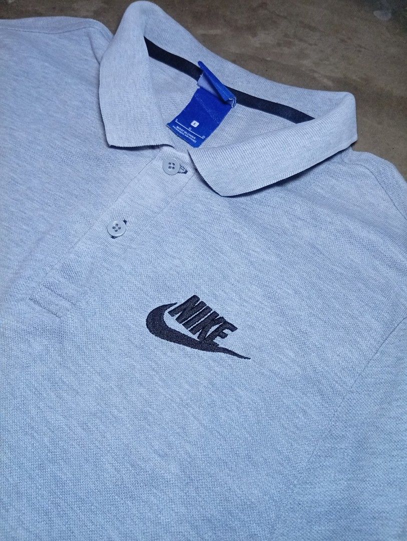 Nike grey polo shirt size L (Category: Tshirts & Polo Shirts ) located in Legazpi City. Submitted by thriftfinds-25 (Listing ID 1467265753, Image 2). Description: - Brand: Nike - Item: Polo Shirt - Color: Grey with contrasting dark inner collar taping - Size: Large (L) slim fit 19x28 - Material: Classic cotton pique fabric - Details: Two-button placket with branded buttons, embroidered black Nike logo on the chest - Origin: Made in China - Condit