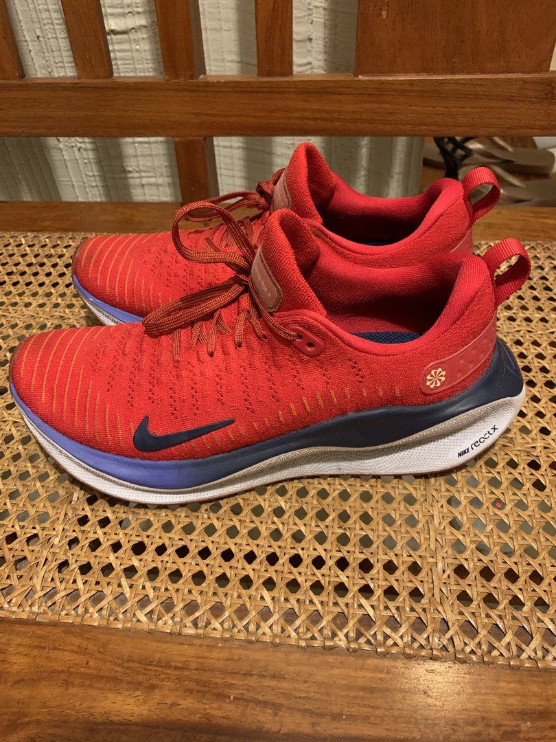 Nike ReactX Infinity Run 4 Red Blue Running Shoes (Category: Sneakers) located in Makati City. Submitted by movingpeach (Listing ID 1467232923, Image 2). Description: Nike ReactX Infinity Run 4 sneakers in red, navy blue, and white. Flyknit upper with classic lace-up closure. Cushioned ReactX midsole provides a smooth ride. Dark swoosh branding on the side. Some scuff marks on the white sole near the heel area from previous wear, otherwise clean 