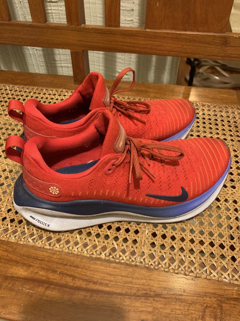 Nike ReactX Infinity Run 4 Red Blue Running Shoes (Category: Sneakers) located in Makati City. Submitted by movingpeach (Listing ID 1467232923, Image 1). Description: Nike ReactX Infinity Run 4 sneakers in red, navy blue, and white. Flyknit upper with classic lace-up closure. Cushioned ReactX midsole provides a smooth ride. Dark swoosh branding on the side. Some scuff marks on the white sole near the heel area from previous wear, otherwise clean 