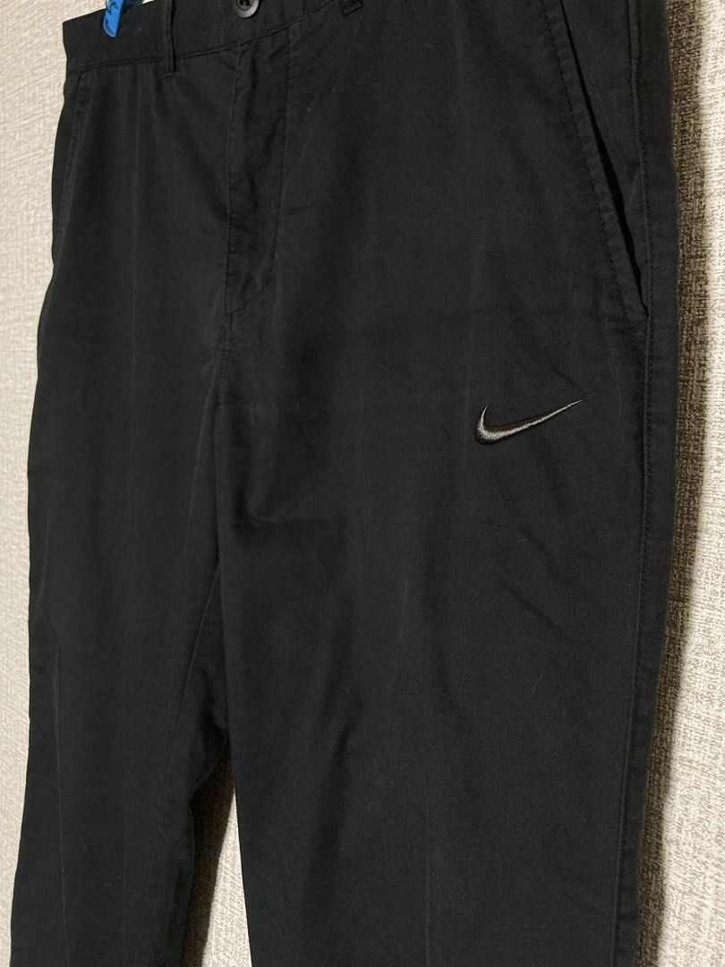 Nike The Athletic Dept Black Chino Pants (Category: Trousers) located in Baguio. Submitted by drip_n_drop (Listing ID 1467325149, Image 2). Description: - Color: Black - Closure: Button closure with zipper fly - Branding: Embroidered Nike swoosh on front left leg and small 'the athletic dept.' patch on back right pocket - Pockets: Two front pockets and two back welt pockets - Style: Versatile and comfortable for casual wear or everyday outfits.