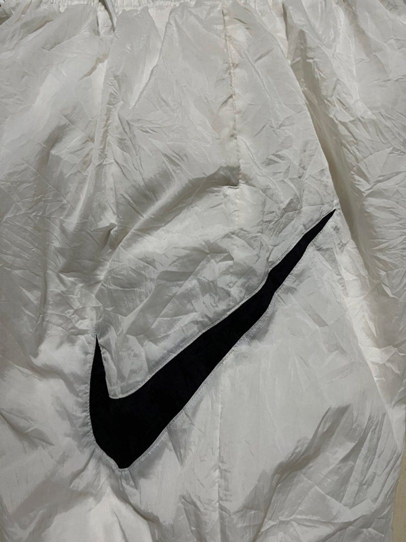 Nike White Track Pants Windrunner Joggers DM6184-100 (Category: Joggers) located in Pasay City. Submitted by Oboyyy (Listing ID 1467254155, Image 2). Description: - Brand: Nike - Item: Windrunner Track Pants - Color: White with large black Swoosh logo - Size: Medium - Product Code: DM6184-100 - Features: Elastic waistband with adjustable drawstring, inner mesh lining - Condition: Clean and ready to wear - Origin: Made in China.
