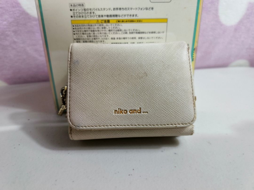 Niko and... beige trifold wallet (Category: Wallets & Card holders) located in San Leonardo. Submitted by burgossanleonardo.12345 (Listing ID 1467279410, Image 1). Description: - Brand: Niko and... - Color: Beige - Material: Textured synthetic leather with gold embossed branding - Design: Trifold wallet with a convenient side zip compartment for coins - Size: Compact, measures roughly 10cm across - Condition: Used with minor surface marks as show