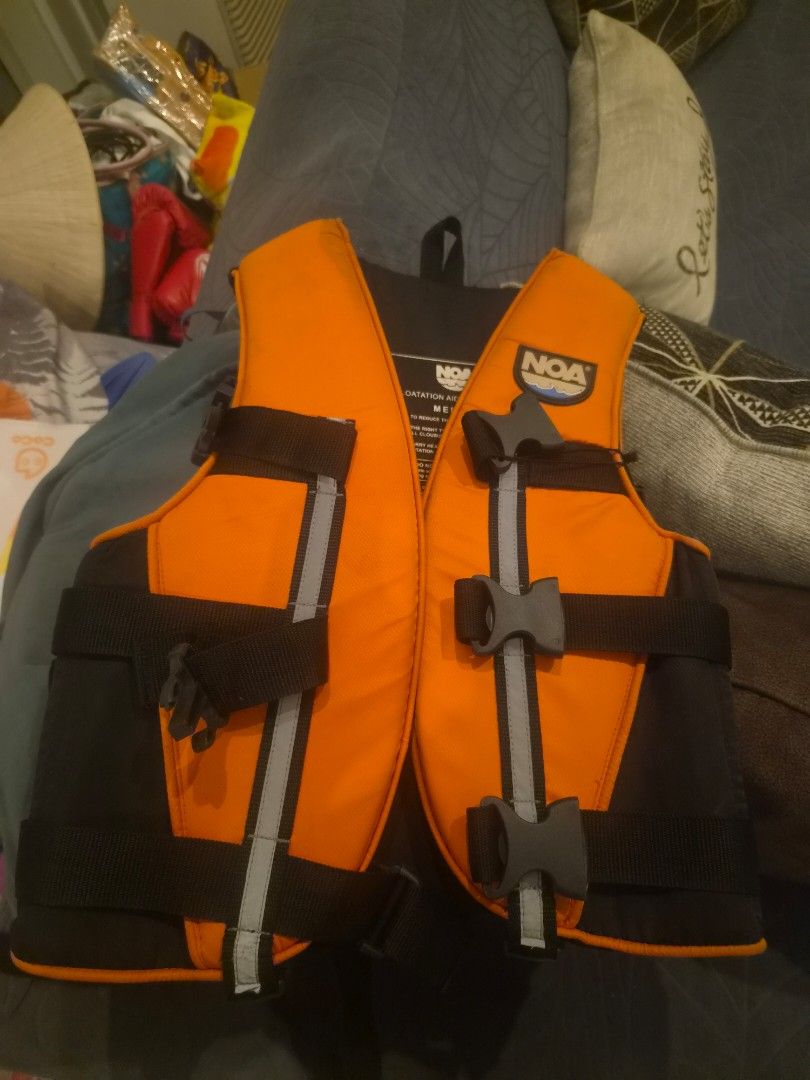 NOA Medium Life Jacket (Category: Water Sports) located in Muntinlupa City. Submitted by chubby_daddy82 (Listing ID 1467277486, Image 1). Description: - Brand: NOA Floatation Aid / Type III PFD - Size: Medium - Color: High-visibility orange and black with reflective stripes - Fit: Three adjustable quick-release buckle straps - Safety: Printed safety warnings and care instructions inside - Usage: Perfect for water sports and recreational boating.