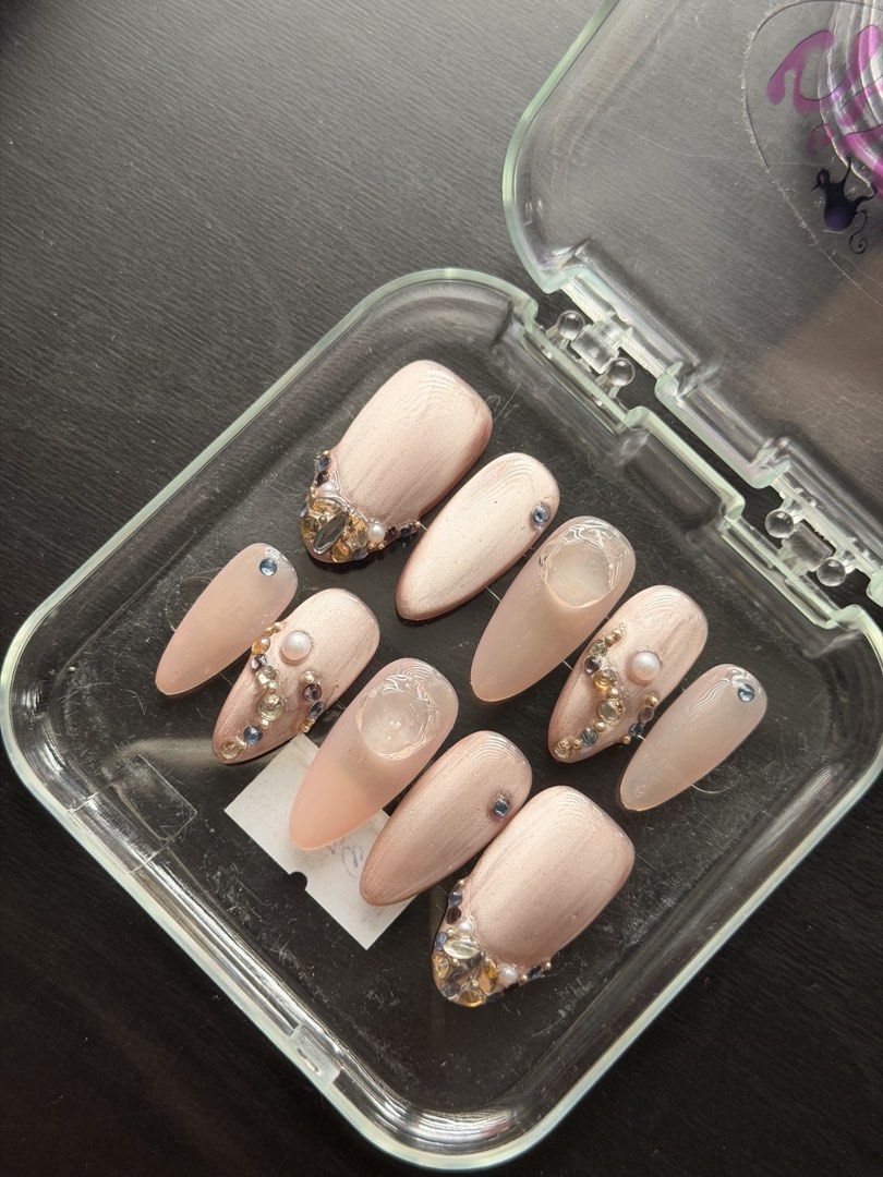 Nude Rhinestone Pearl Custom Press-On Nails Set (SIZE M) (Category: Hands & Nails) located in Quezon City. Submitted by ninny.ph (Listing ID 1467190459, Image 3). Description: - Design: Neutral nude cat-eye finish with rhinestones, pearls, and 3D textured gel art - Shape & Length: Almond shape, ready-to-wear handmade set - Inclusion: 10 pieces of press-on nails - Packaging: Comes in a convenient clear plastic carrying case - Note: Adhesive not in
