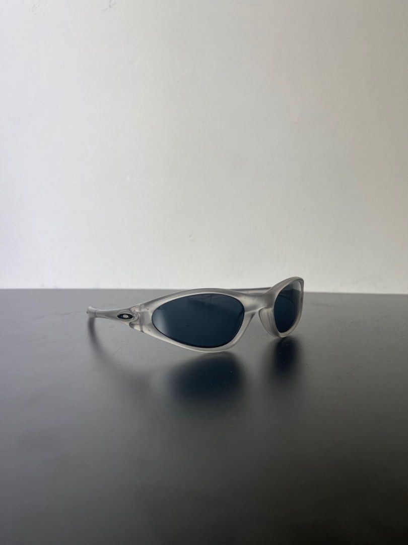 Oakley minute 1.0 (Category: Sunglasses & Eyewear) located in Manila. Submitted by mine2ownit (Listing ID 1467303943, Image 1). Description: - Frame: Transparent gray with a curved wrap-around shape - Lenses: Dark lenses for sunny days - Detail: Iconic ellipse logo on both temples - Style: Great for streetwear and easy to match with daily outfits.
