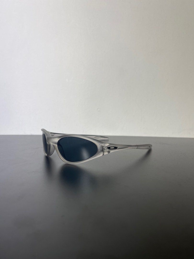 Oakley minute 1.0 (Category: Sunglasses & Eyewear) located in Manila. Submitted by mine2ownit (Listing ID 1467303943, Image 3). Description: - Frame: Transparent gray with a curved wrap-around shape - Lenses: Dark lenses for sunny days - Detail: Iconic ellipse logo on both temples - Style: Great for streetwear and easy to match with daily outfits.