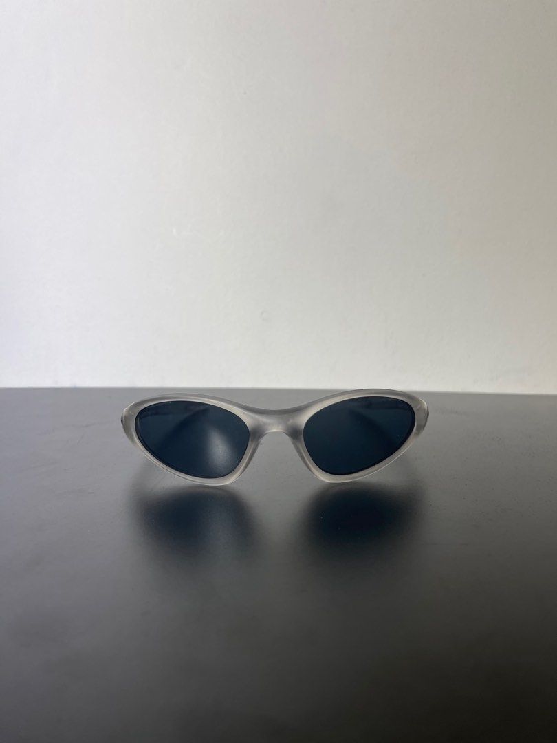 Oakley minute 1.0 (Category: Sunglasses & Eyewear) located in Manila. Submitted by mine2ownit (Listing ID 1467303943, Image 2). Description: - Frame: Transparent gray with a curved wrap-around shape - Lenses: Dark lenses for sunny days - Detail: Iconic ellipse logo on both temples - Style: Great for streetwear and easy to match with daily outfits.