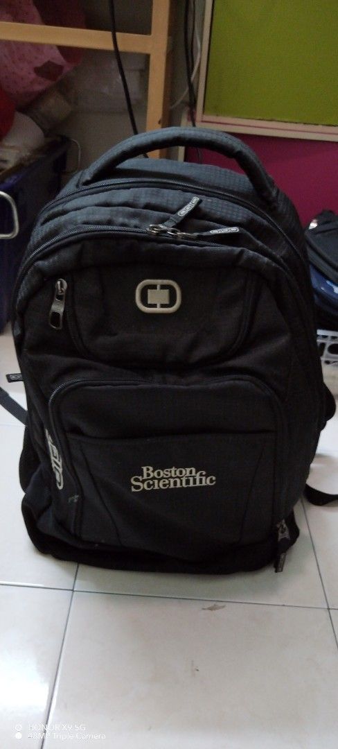 Black Backpack (Category: Backpacks) located in Butterworth. Submitted by jenny_yeoh97 (Listing ID 1467353022, Image 1). Description: - Brand: OGIO - Design: Black with Boston Scientific logo on front pocket - Storage: Multiple zipped compartments for organized packing - Comfort: Padded top handle for easy carrying - Material: Durable fabric suitable for daily wear and tear - Capacity: Spacious interior ideal for laptops, travel gear, and daily e