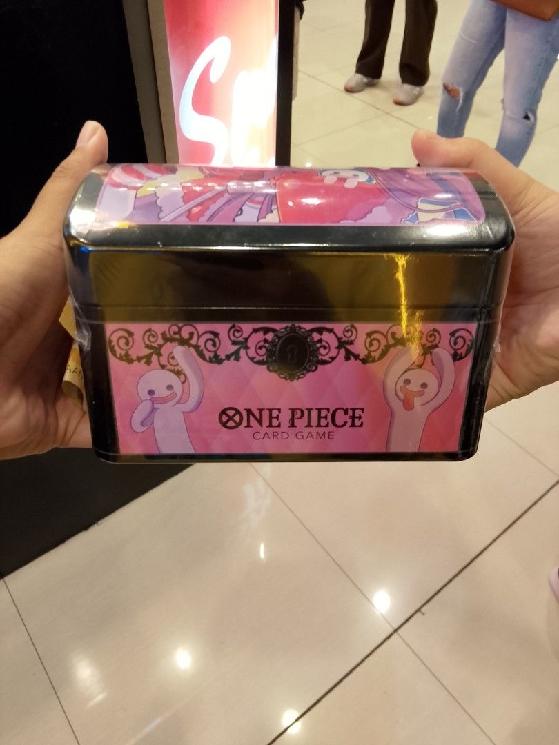 One Piece Card Game Storage Box Tin Perona Design (Category: Card Boxes & Cases) located in San Pedro. Submitted by pokeprimo22 (Listing ID 1467238225, Image 1). Description: - Official One Piece TCG metal storage chest - Adorable Perona and ghost pink decorative wrap - Brand new and still sealed in original plastic film - Durable solid metal construction with a secure hinged lid - Perfect container for card decks, sleeves, and TCG accessories - 