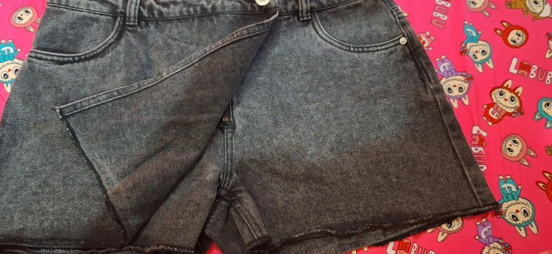 ONLY Denim Skort Size L (Category: Skirts) located in Manila. Submitted by katkween23 (Listing ID 1467191636, Image 2). Description: - Color/Wash: Black acid wash with a textured faded look - Style: Wrap-style front overlay with shorts underneath - Size: L (tag attached inside back waistband) - Features: Button waist closure, belt loops, and standard pockets - Condition/Vibe: Great casual piece for everyday outfits.