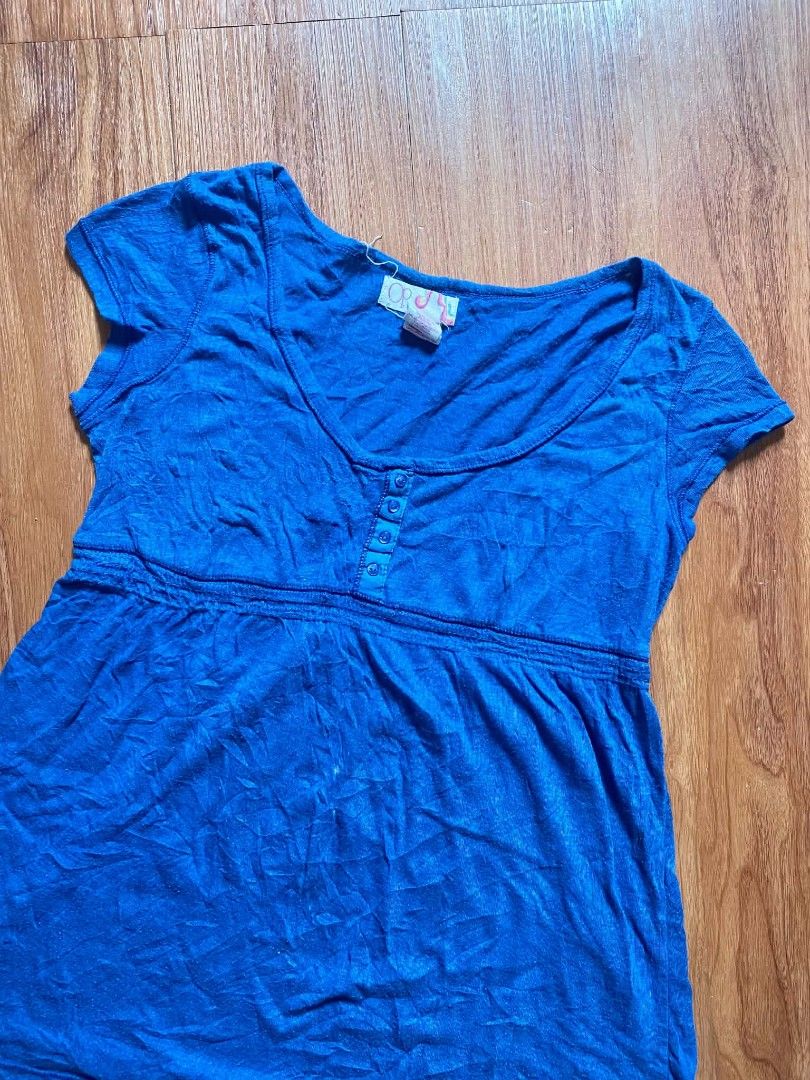 OP Blue Scoop Neck Button Detail Top (Category: Blouses) located in Malasiqui. Submitted by finnley26 (Listing ID 1467240748, Image 2). Description: - Brand: OP - Color: Bright blue - Neckline: Scoop neck with four small front buttons - Sleeves: Short cap sleeves - Waistline: Empire waist with gathered seam - Fit: Lightweight and relaxed - Condition: Worn a few times, washed, and ready to wear.