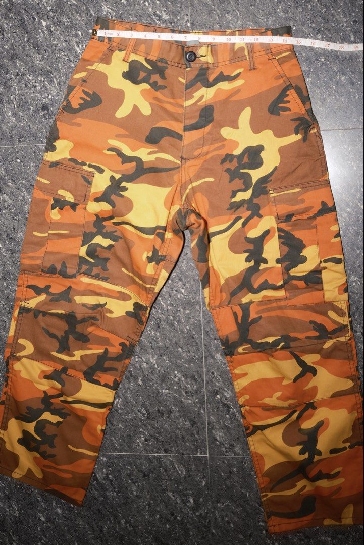 Orange Camo Cargo Pants Utility Trousers (Category: Joggers) located in Guiguinto. Submitted by aries_ji (Listing ID 1467250008, Image 3). Description: - Vibrant orange and yellow camouflage design - Multiple utility pockets on sides and back - Adjustable back straps on the waistband for a custom fit - Secure button closure and zip fly - Comfortable cotton blend material - Classic straight leg cut.