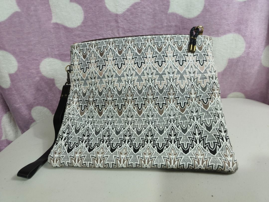 Patterned Fabric Clutch Handbag with Wrist Strap (Category: Clutches) located in San Leonardo. Submitted by burgossanleonardo.12345 (Listing ID 1467278428, Image 1). Description: - Style: Textured clutch bag with a geometric zig-zag pattern - Colors: Black, white, and tan - Dimensions: Approx. 33 cm (width) x 28 cm (height) - Strap: Dark leather wrist strap (approx. 17 cm) - Closure: Secure top zipper - Condition: Clean inside and out, ready to u