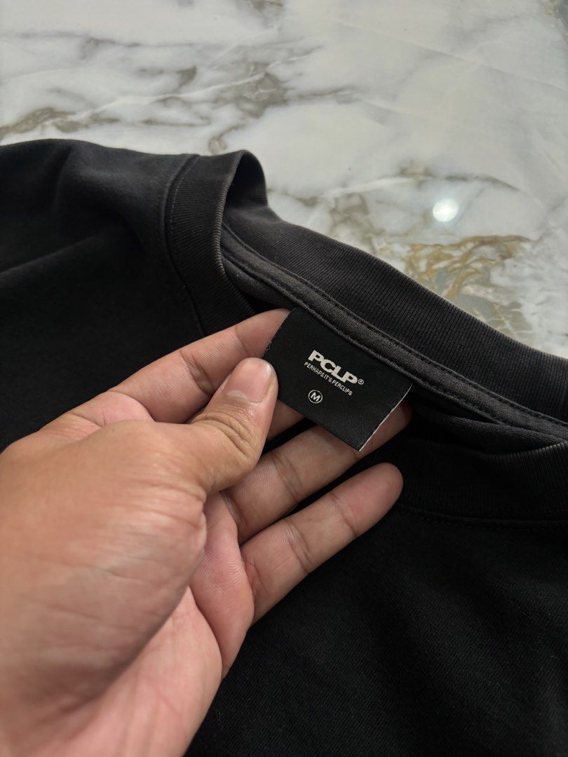 PCLP Black Graphic Tee Size M (Category: Shirts) located in Cavite. Submitted by gelloots (Listing ID 1467197656, Image 3). Description: PCLP Black Graphic Tee, Size M. Features a small chest logo and large futuristic back graphic. Soft cotton fabric with a relaxed fit. Clean condition and ready to wear. Dimes : 22.5x28 Condition : Good Condition Color rate : 9.5/10 Size on tag: medium Wash.