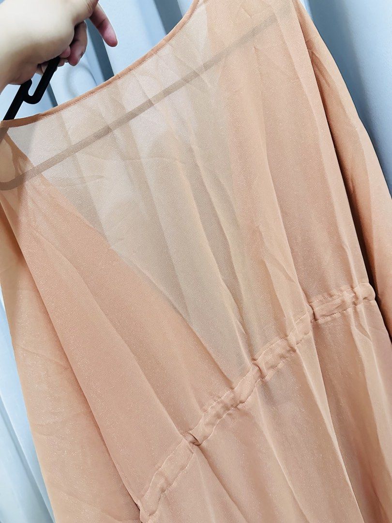 Sheer Beach Cover up dress (Category: Dresses) located in Quezon City. Submitted by mananglinette (Listing ID 1467176238, Image 3). Description: - Color/Finish: Sheer peach with a subtle shimmer - Design: Deep V-neckline, flutter sleeves, and flowy tiered hem - Fit: Adjustable drawstring waist for a flattering silhouette - Fabric: Lightweight and breathable, ideal for beach days - Use: Perfect throw-on piece for swimwear Cover up for swimsuit.