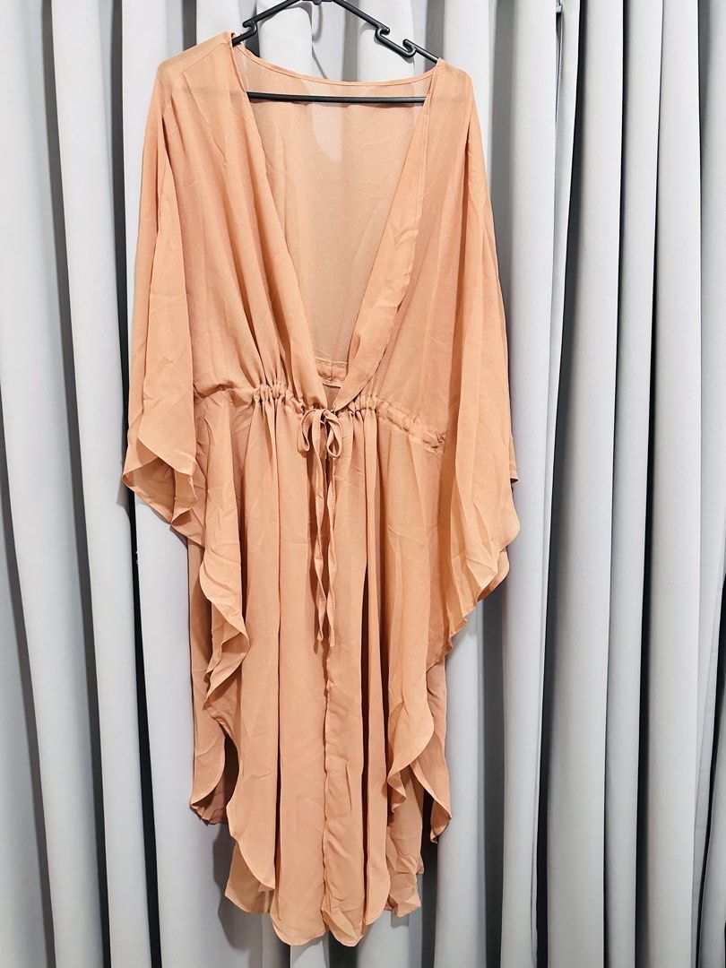 Sheer Beach Cover up dress (Category: Dresses) located in Quezon City. Submitted by mananglinette (Listing ID 1467176238, Image 1). Description: - Color/Finish: Sheer peach with a subtle shimmer - Design: Deep V-neckline, flutter sleeves, and flowy tiered hem - Fit: Adjustable drawstring waist for a flattering silhouette - Fabric: Lightweight and breathable, ideal for beach days - Use: Perfect throw-on piece for swimwear Cover up for swimsuit.