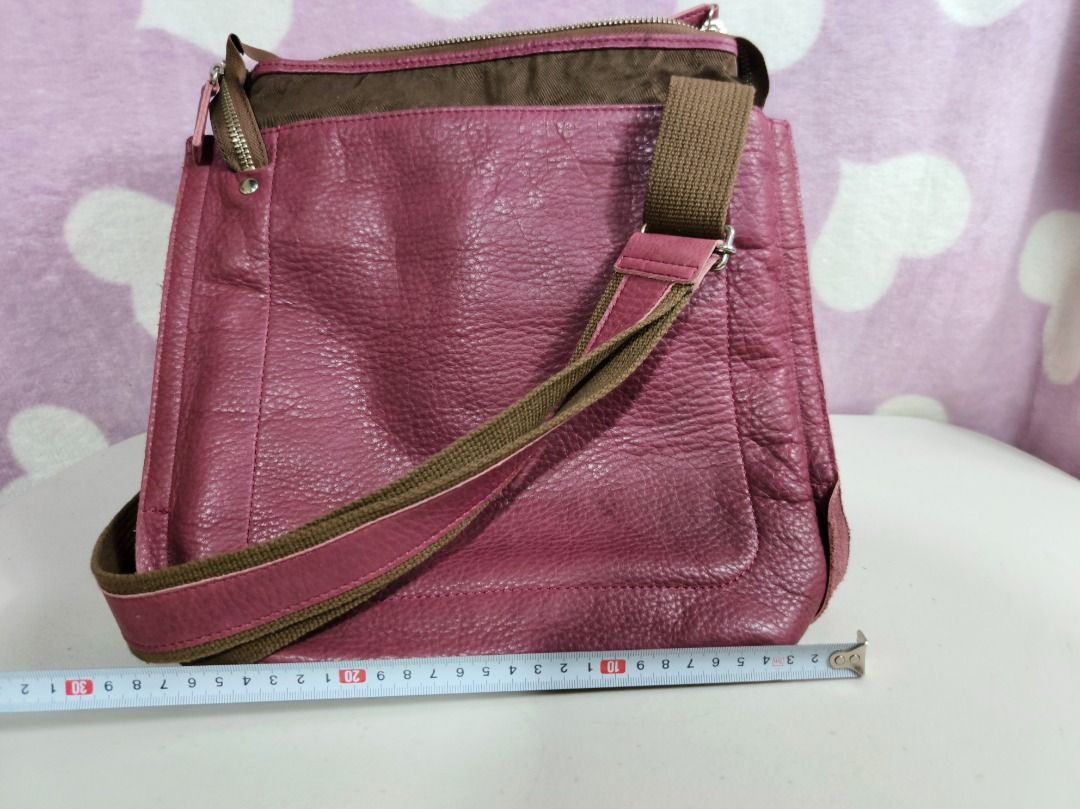 Pink leather cross body shoulder bag (Category: Cross-body Bags) located in San Leonardo. Submitted by burgossanleonardo.12345 (Listing ID 1467277566, Image 2). Description: - Stylish pink faux leather shoulder bag with brown trim - Dimensions: approx. 30 cm W x 30 cm H - Adjustable strap for comfortable wear - Secure zip top closure - Interior includes one zip pocket and handy slip pockets - Perfect size for daily casual use with great storage.
