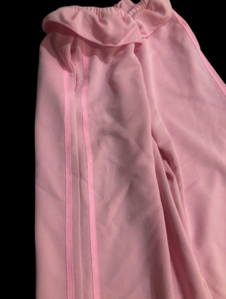 Pink Wide Leg Track Sweatpants (Category: Jeans) located in Limay. Submitted by blueskyjiminie (Listing ID 1467297913, Image 2). Description: - Color: Soft pink - Fit: Relaxed, flowy wide-leg design - Waistband: Elastic ruffled waist with matching adjustable drawstring - Detail: Classic side striping down the legs - Material: Smooth and comfortable polyester fabric - Best for: Casual days, errands, or cozy lounging.