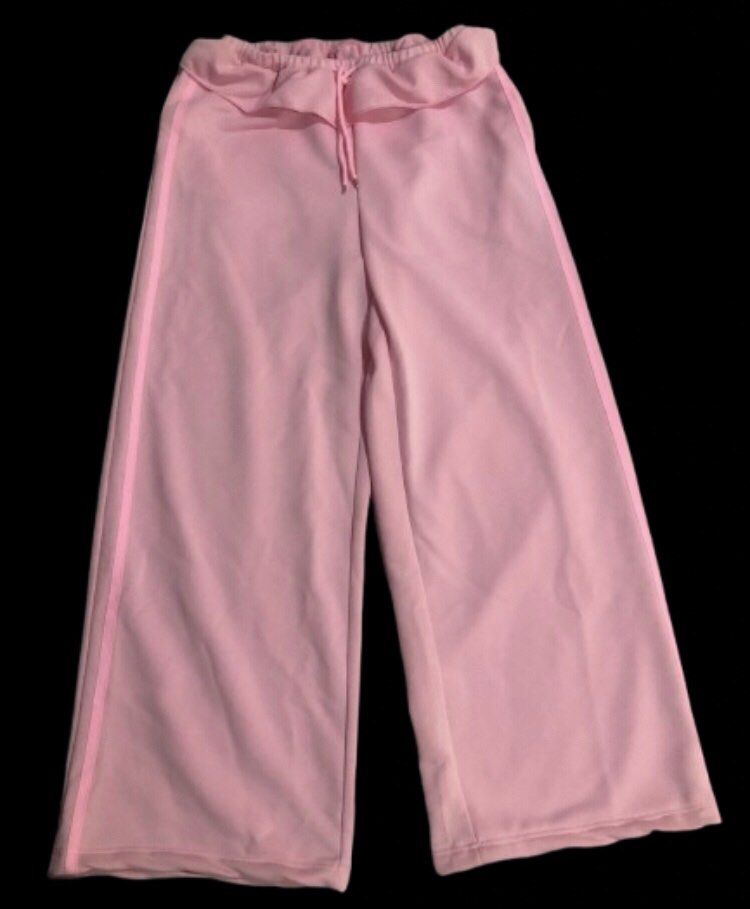 Pink Wide Leg Track Sweatpants (Category: Jeans) located in Limay. Submitted by blueskyjiminie (Listing ID 1467297913, Image 1). Description: - Color: Soft pink - Fit: Relaxed, flowy wide-leg design - Waistband: Elastic ruffled waist with matching adjustable drawstring - Detail: Classic side striping down the legs - Material: Smooth and comfortable polyester fabric - Best for: Casual days, errands, or cozy lounging.