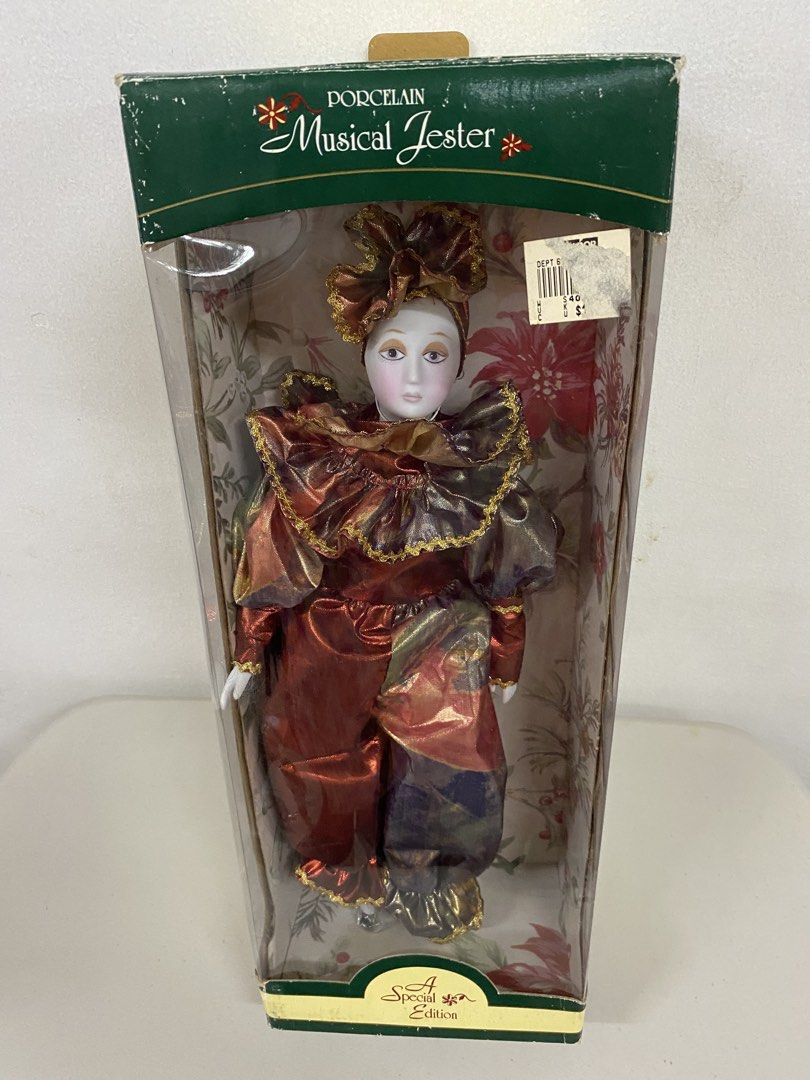 Porcelain Musical Jester Special Edition Doll (Category: Figurines & Statues) located in San Juan City. Submitted by puredeer-d87d (Listing ID 1467353383, Image 1). Description: - Porcelain musical jester doll with delicate painted facial features - Dressed in a vibrant, shiny red and gold ruffled outfit with matching hat - Built-in wind-up musical mechanism located on the back - Comes complete with original printed display box featuring holiday 