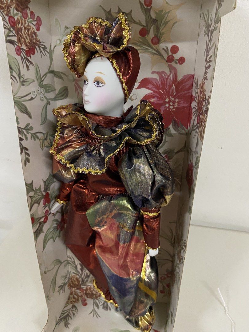 Porcelain Musical Jester Special Edition Doll (Category: Figurines & Statues) located in San Juan City. Submitted by puredeer-d87d (Listing ID 1467353383, Image 2). Description: - Porcelain musical jester doll with delicate painted facial features - Dressed in a vibrant, shiny red and gold ruffled outfit with matching hat - Built-in wind-up musical mechanism located on the back - Comes complete with original printed display box featuring holiday 